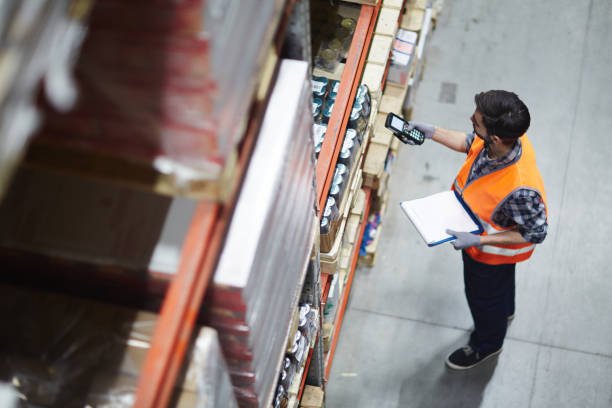 Home worker with scanner making review of goods in warehouse